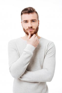 Yakışıklı delikanlı kameraya beyaz arka plan üzerinde seyir dikey portresi. Çekici sakallı adam çenesini izole