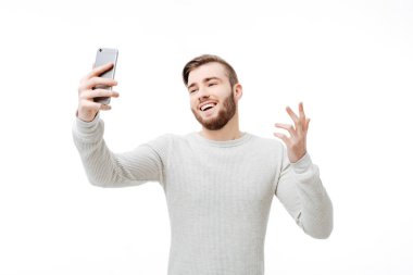 Mutlu genç adam alarak selfie ve neden gösterilen beyaz arka plan üzerinde jest
