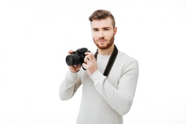 Genç adam izole Dslr fotoğraf makinesi ile fotoğraf makinesi ve alma resim bakarak sakallı