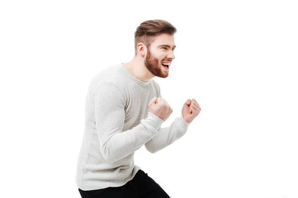 Young man celebrating the win with yes gesture. Guy celebrating the win or rooting for success over white background — Stock Photo, Image