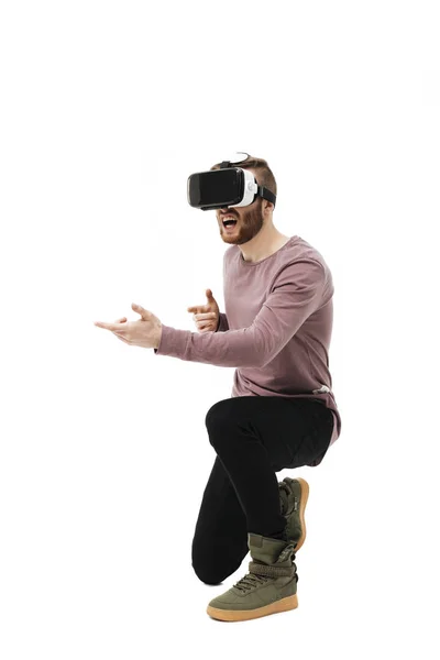 Retrato de menino legal em óculos de realidade virtual jogando no jogo de tiro no fundo branco. Jovem usando óculos de realidade visual isolados — Fotografia de Stock