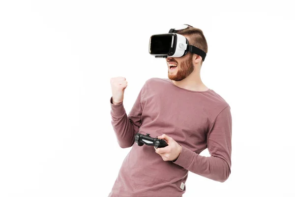 Ritratto di giovane uomo in piedi in occhiali di realtà virtuale con joystick in mano e mostrando "sì" gesto su sfondo bianco. Cool boy giocare in occhiali realtà visiva isolato — Foto Stock