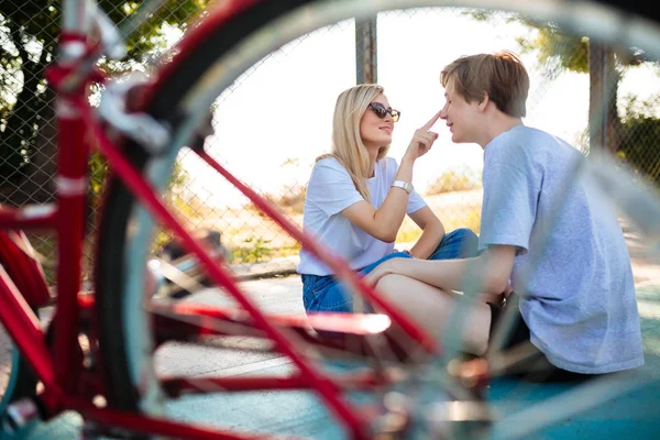 Portret radosny chłopiec i dziewczyna w okulary, siedząc na podłodze i szczęśliwie grać razem. Młoda para piękny zabawy podczas spędzania czasu w parku — Zdjęcie stockowe