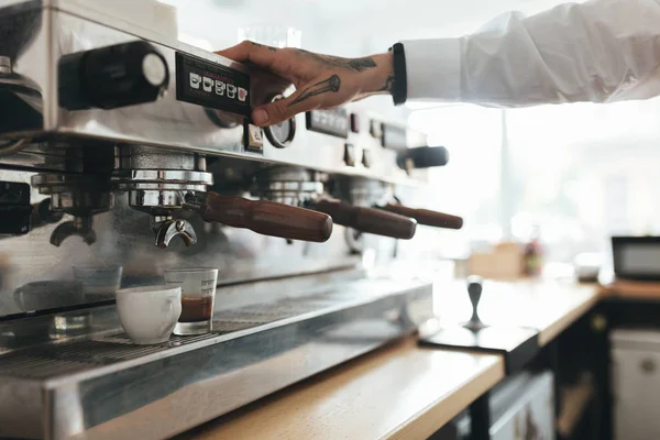 Joven manos trabajando con la máquina de café en la cafetería. Primer plano manos baristas preparando café en el mostrador en el restaurante —  Fotos de Stock