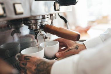 Kahve kahve makinesi restoranda barista eller yukarı kapatın. Adam iki beyaz bardak tutan ve kafede kahve makinesi kahve hazırlama eller