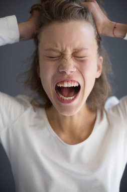 Kafasına elele ve izole gözlerini kapatma genç çığlık Bayan portresi