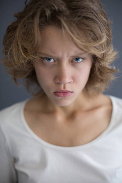 Portrait of young displeased lady  angrily looking in camera isolated