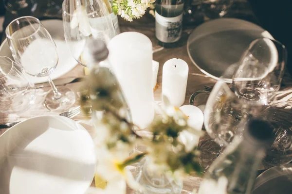Gün batımında düğün Ziyafet. Konuklar, mumlar ve çiçekler, dekore edilmiş için tablo çatal ve çanak çömlek ile servis ve bir masa örtüsü ile kaplı. Kadehlerin, şişe suyu