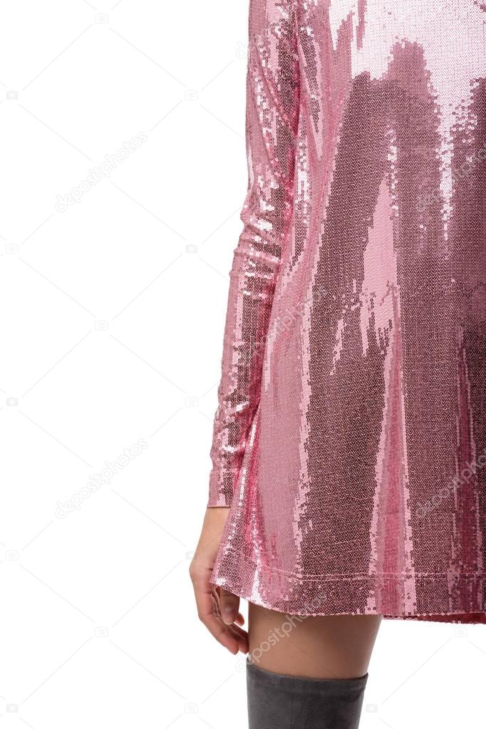 Close up photo of woman body in pink dress in sequins on white background