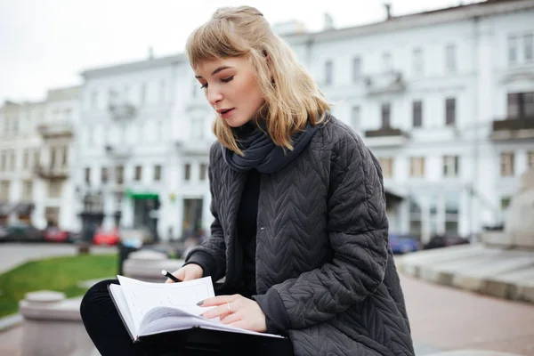 Portret Pięknej Dziewczyny Blond Włosy Siedzi Notesem Ręku Ulicy Miasta — Zdjęcie stockowe