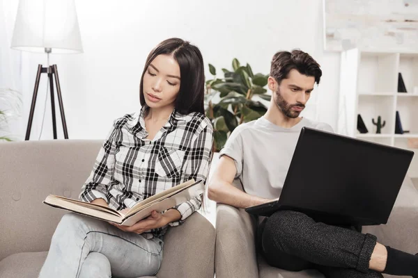 Gyönyörű Hölgy Szék Olvasás Könyv Ember Közelében Működő Laptop Otthon — Stock Fotó