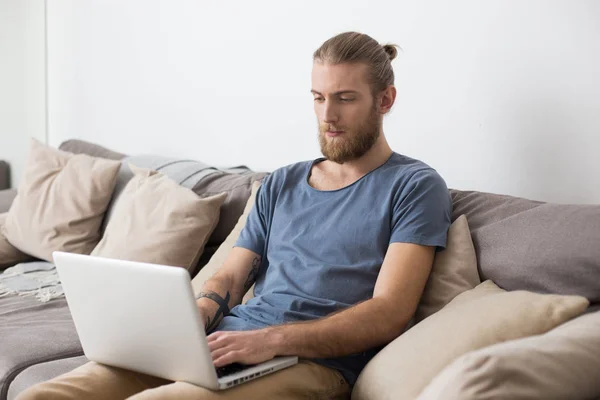 Retrato Del Joven Hombre Reflexivo Sentado Gran Sofá Gris Trabajando — Foto de Stock