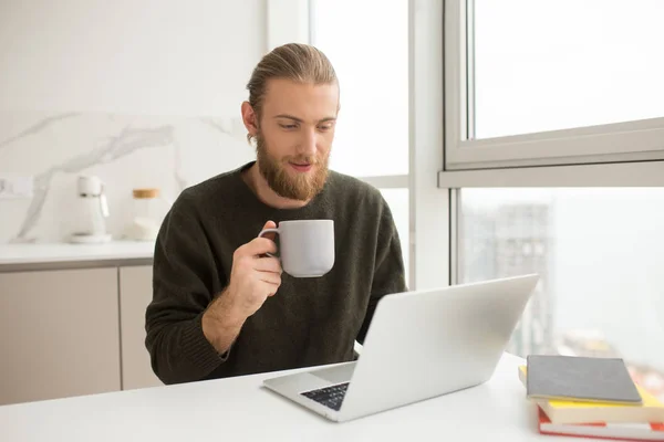 Retrato Joven Sentado Mesa Con Taza Mano Portátil Casa Aislado — Foto de Stock