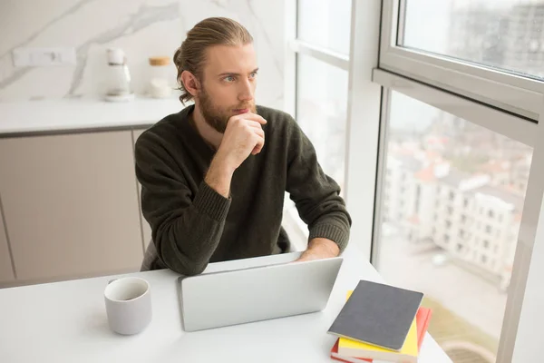 Retrato Hombre Joven Sentado Mesa Trabajando Ordenador Portátil Mientras Que — Foto de Stock