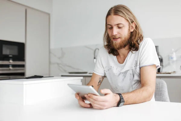 Retrato Joven Sonriente Sentado Usando Una Tableta Digital Cocina Casa — Foto de Stock