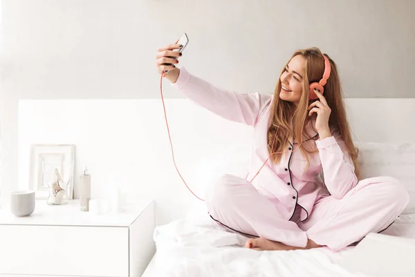 Lachende Jongedame Nachtkleding Zittend Bed Muziek Koptelefoon Luisteren Terwijl Het — Stockfoto