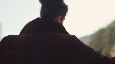 Yakından çekilen, ceketli güzel Afrikalı Amerikalı kız rüyasında açık havada dönüyor.