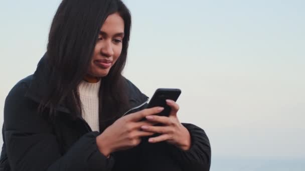 Vonzó Alkalmi Ázsiai Lány Kabát Boldogan Gépelés Mobiltelefon Kültéri — Stock videók