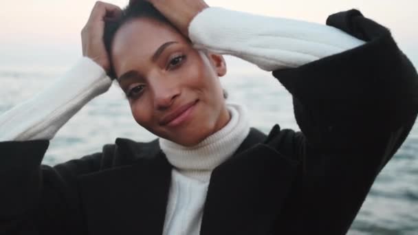 아름다운 아프리카 미국인 소녀의 행복하게 바다에 포즈를 취하는 카메라를 — 비디오