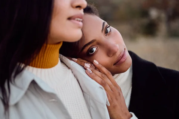 Close up beautiful African American girl thoughtfully looking in camera leaning head on friend shoulder outdoor — ストック写真