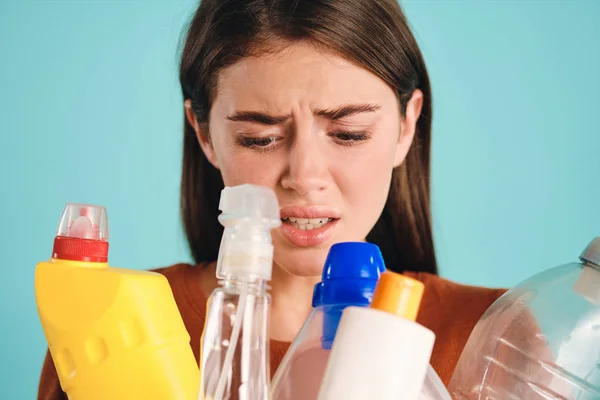 Close-up boos meisje helaas op zoek naar plastic afval over kleurrijke achtergrond — Stockfoto