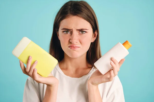 Ragazza sconvolta con rifiuti di plastica in mano tristemente cercando nella fotocamera su sfondo colorato — Foto Stock