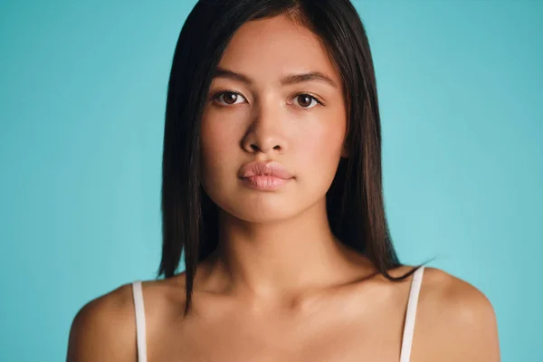 Portrait of beautiful Asian brunette girl confidently looking in camera over colorful background — Stok Foto