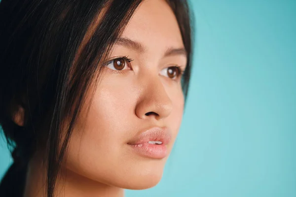 Nær en vakker asiatisk brunette-jente med drømmende blikk på fargerik bakgrunn – stockfoto