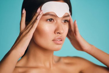 Çekici Asyalı kızı kapat. Renkli arka plan üzerinden kendine güvenerek maske takıyor.