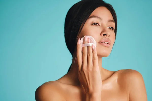 Hermosa chica morena asiática soñando con polvo soplo sobre fondo colorido —  Fotos de Stock