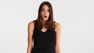 Genç, şoke olmuş, kahverengi saçlı kadın elleri beyaz arka planda korkunç bir şekilde yüzünü örtüyor.