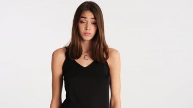 Genç, hayal kırıklığına uğramış kahverengi saçlı kadın. Üzücü bir şekilde yüzünü beyaz arka planla kapatıyor.