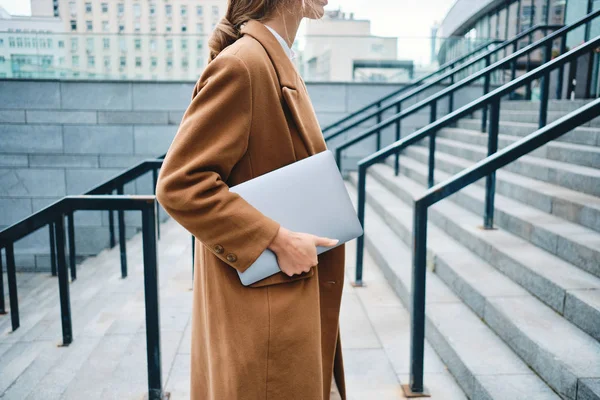 Primer plano elegante mujer de negocios en abrigo con portátil en la calle de la ciudad —  Fotos de Stock