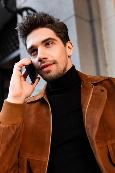 Porträt eines jungen attraktiven, lässigen Mannes, der im Freien mit dem Handy spricht — Stockfoto