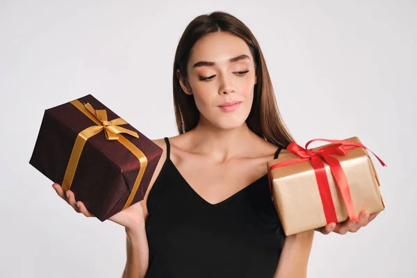 Güzel, şık bir kız, beyaz arka planda hediye kutularını incelikle tutuyor. — Stok fotoğraf