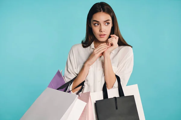 Gyönyörű alkalmi lány bevásárló táskák figyelmesen nézett félre színes háttér — Stock Fotó