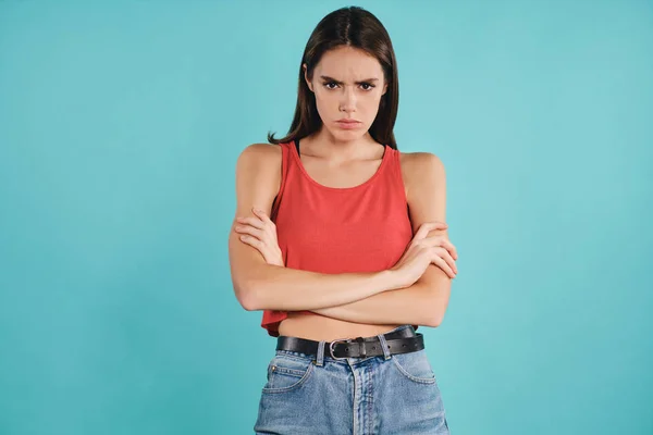 Menina casual perturbado segurando as mãos cruzado furiosamente olhando na câmera sobre fundo colorido — Fotografia de Stock