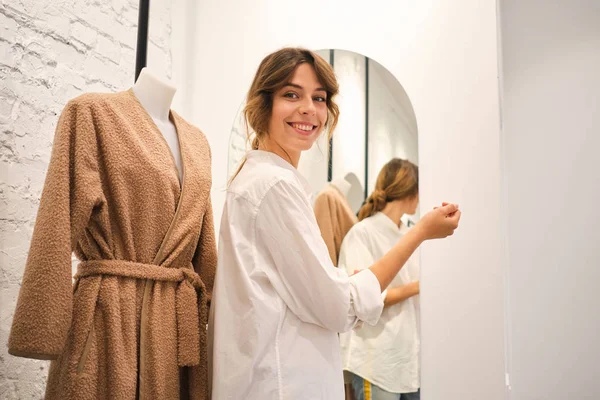 Fiatal csinos nő boldogan dolgozik kamerával dolgozik műhelyben az új divat gyűjtemény — Stock Fotó