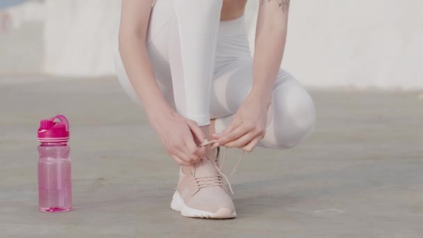 年轻的女运动员把鞋带绑在运动鞋上准备户外运动 — 图库视频影像