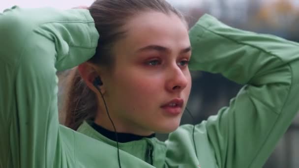 Portret Van Een Aantrekkelijke Sportieve Meisje Oortelefoons Koppelverkoop Haar Staart — Stockvideo