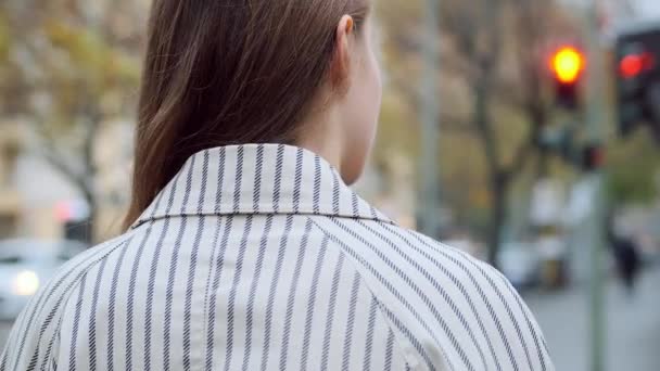 在城市街道上等红绿灯的穿着外套的迷人的时髦女孩的背景图片 — 图库视频影像