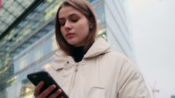 Portret Przypadkowej Dziewczyny Kurtce Telefonem Komórkowym Rozmysłem Czekającej Ulicy Miejskiej — Wideo stockowe