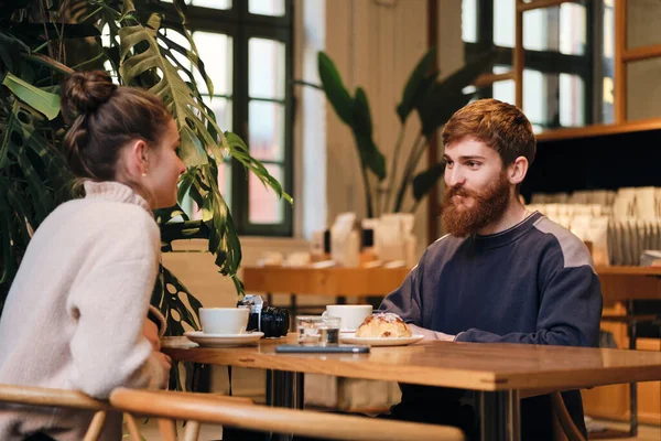 Joven pareja atractiva beber café descansando juntos en acogedora cafetería — Foto de Stock