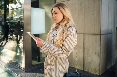 Genç ve güzel bir kadının tablet tablet kullanışının yan görüntüsü.