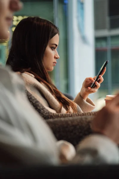 Side view of beautiful girl intently using cellphone in cefe — Stock Photo, Image