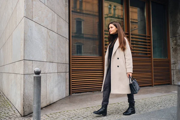 Hermosa chica morena con estilo en abrigo felizmente caminando por la calle de la ciudad — Foto de Stock