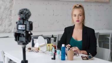 Beautiful beauty blogger girl preparing recording make-up tutorial video for internet