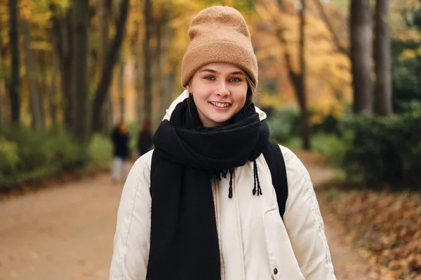 Portrait of casual smile girl happily looking in camera in beautiful winter n park — Stok Foto