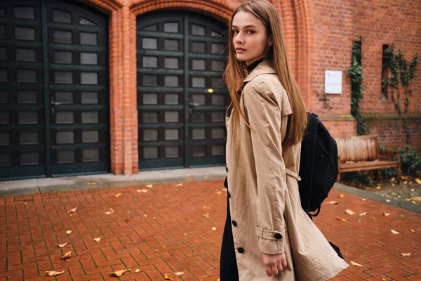 Schöne stilvolle Mädchen mit Rucksack zuversichtlich in die Kamera zu Fuß durch die Straße allein — Stockfoto