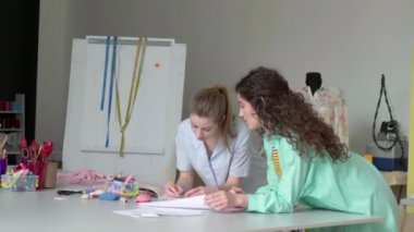 Samimi terzi stüdyosunda birlikte çalışan iki güzel kız. Moda tasarımı konsepti